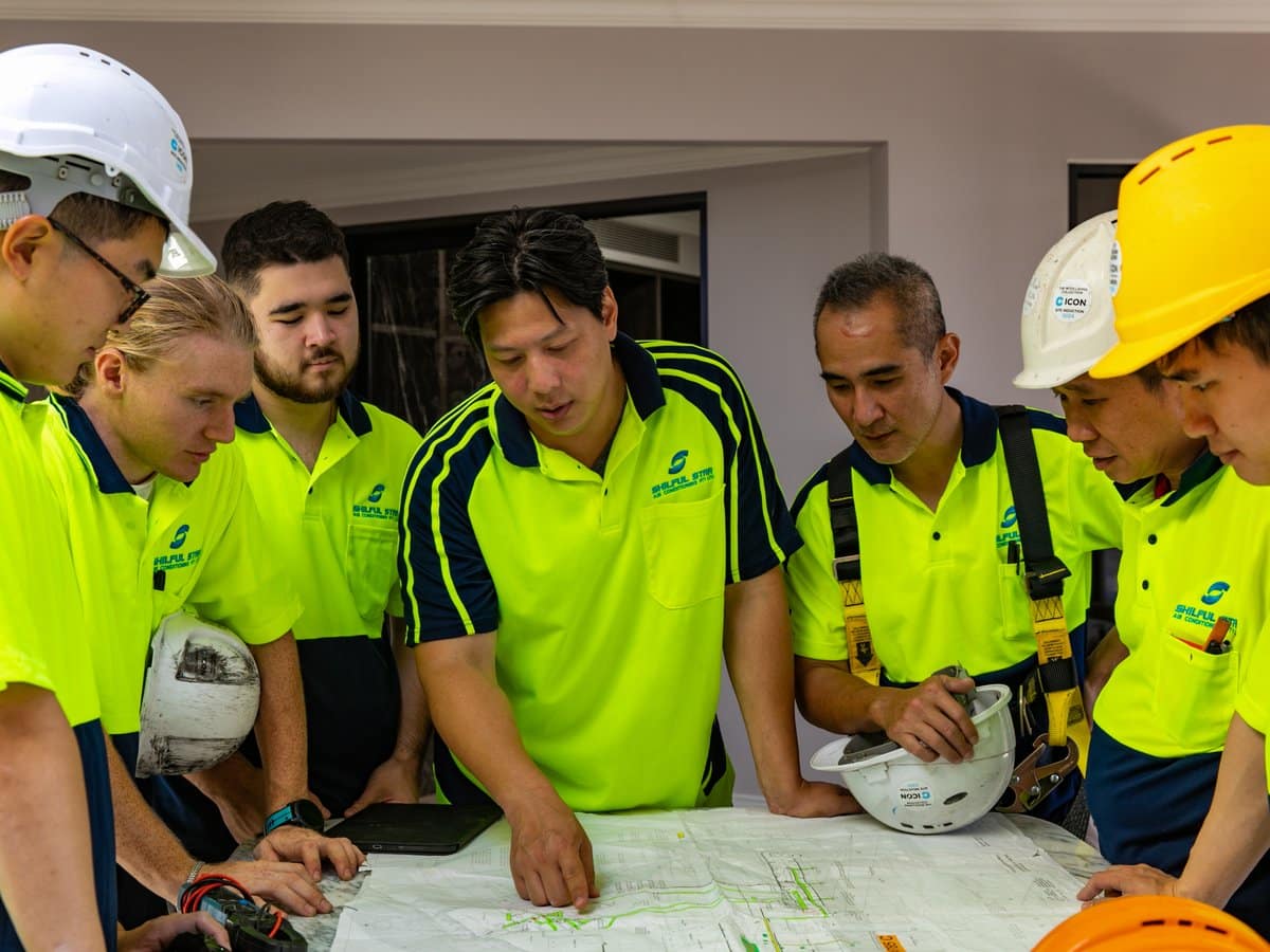 Skilful Star team reviewing marked-up mechanical services drawings on site