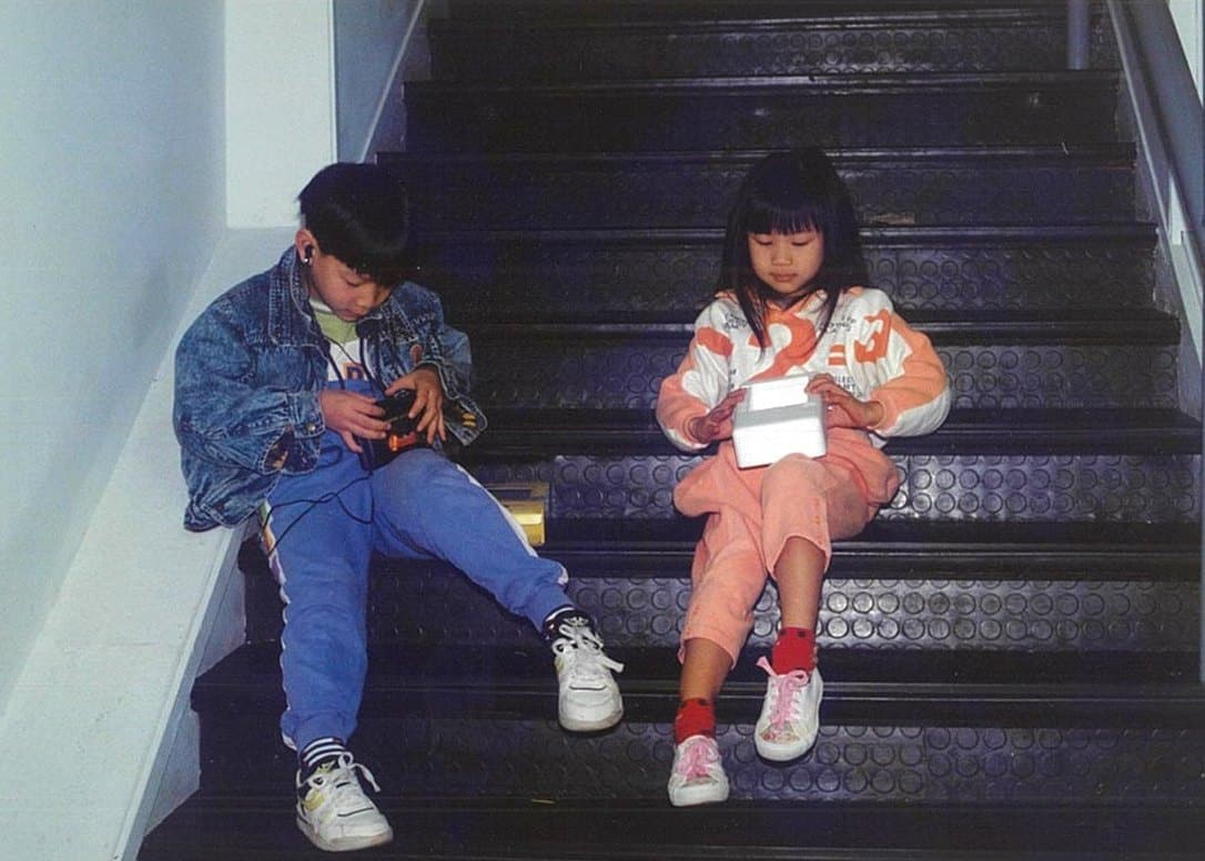 Kinson and his sister on the steps of the family store, early 1990s