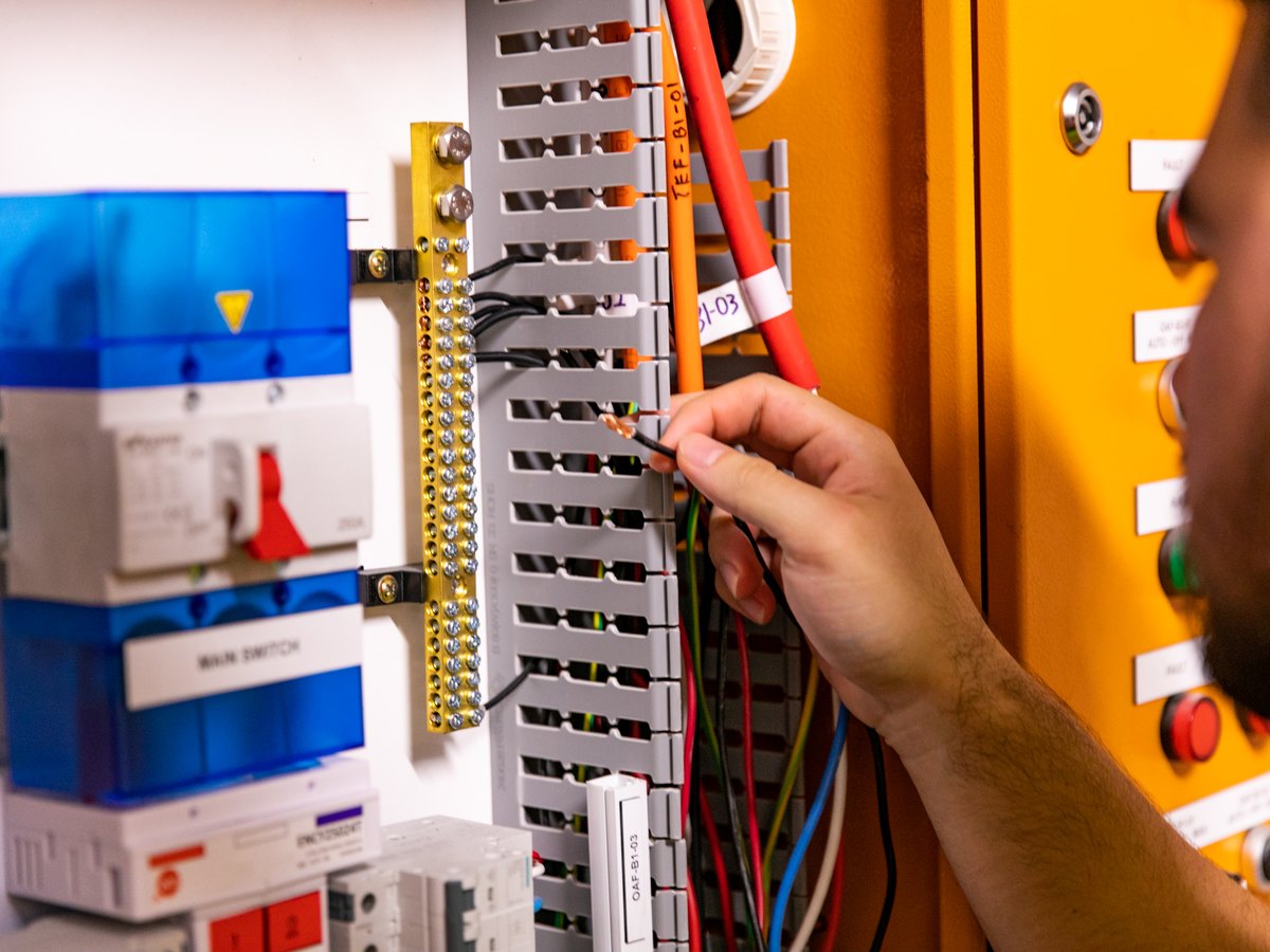 Skilful Star technician testing terminals in a mechanical switchboard