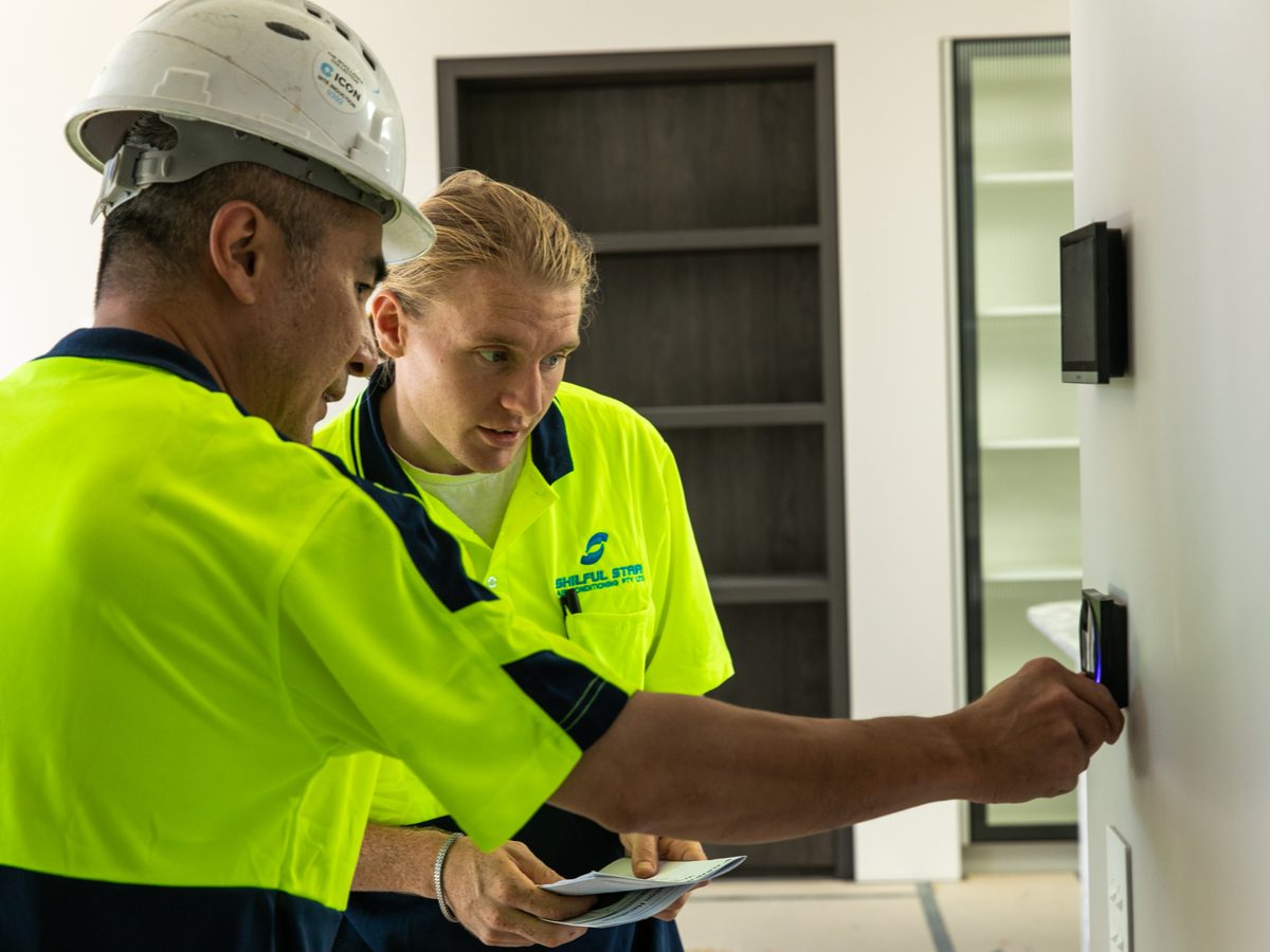 Skilful Star technicians commissioning an air conditioning wall controller in a new Sydney home